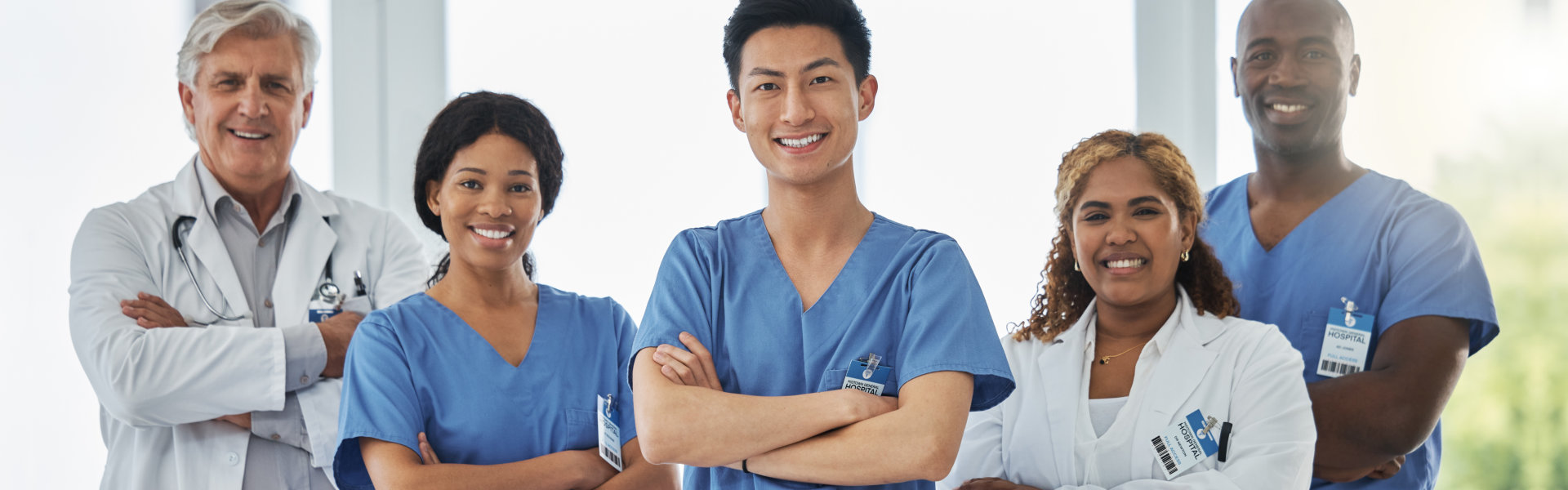 portrait and team of doctors with arms crossed standing together in hospital